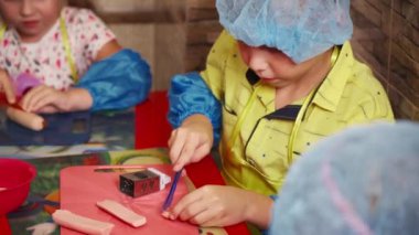 Çocuklar yemek pişirmeyi öğrenirler. Mutfağa özenle yardım eden bir çocuğun yüzündeki ifade..