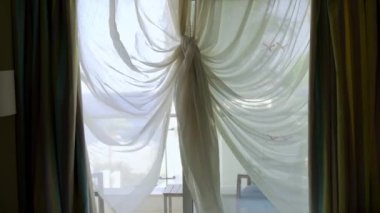 Kelebek şeklinde güzel bir perde hafif bir esintide yavaşça sallanıyor. Otelin perdesini sallar denize bakan perdeyi.