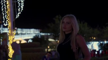 Şehrin neon ışıklarının arkasında genç bir kız..