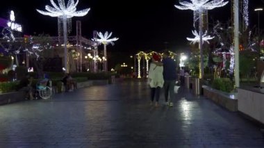 Sharm Al Sheikh, Mısır, 10 Eylül 2021. Soho Meydanı birçok neon ışıklarıyla aydınlatılır. Afrika 'da popüler bir tatil beldesinde tatil yeri. Bir çift aşık gece şehirde dolanıyor..