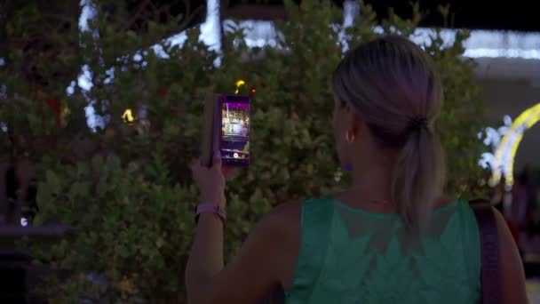 Orta Yaşlı Bir Kız Akşamları Cep Telefonuyla Şehir Dekorasyonunun Fotoğraflarını — Stok video
