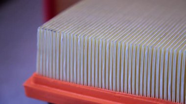 Ayrıntılı kağıt katları ve filtreleme dokusunu gösteren bir araba hava filtresi yapısının yakın çekimi.