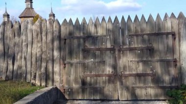 Sivri uçlu kazık ve ağır dövülmüş metal menteşeli eski ahşap kapı ya da çam ağacı. Tarihi arkaplan