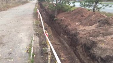 Yol kenarında çitlerle çevrili bir çukur kazdık.