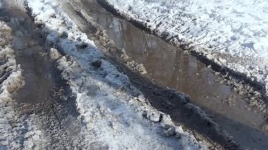 Buzlu, karlı kış yolunda büyük, karanlık bir su birikintisi..