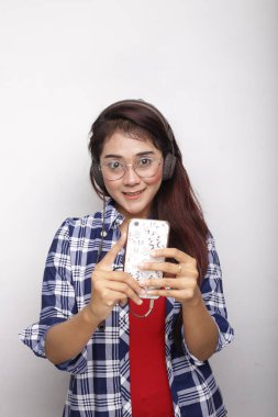 Asyalı kadın portresi. Klasik kulaklıkla akıllı telefondan müzik dinle..