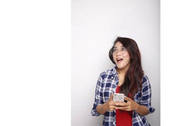 Asyalı kadın akıllı telefon beyaz arkaplanda boş alan gösteriyor.