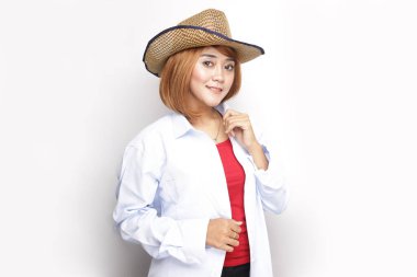 Güzel kovboy kız. Kovboy kız şapkasını düzeltiyor ve ayakta gülümsüyor.