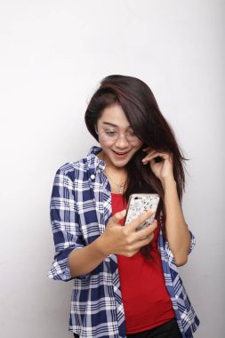 Asyalı kadın akıllı telefon beyaz arkaplanda boş alan gösteriyor.