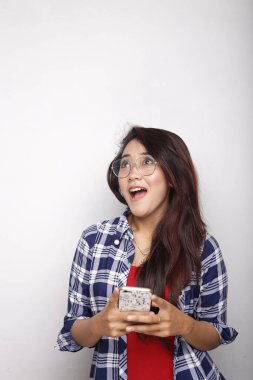 Asyalı kadın akıllı telefon beyaz arkaplanda boş alan gösteriyor.