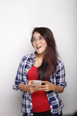 Asyalı kadın akıllı telefon beyaz arkaplanda boş alan gösteriyor.