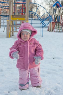 Kız dikkatle kar üzerinden gider. Gülümsüyor. Yanağında bir yırtık. Kış.