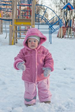 Kız. Gülümsüyor. Yanağında bir yırtık. Kış.