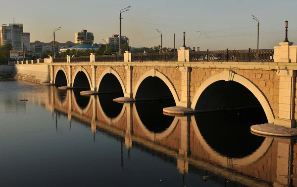 Bron över floden Miass i Tjeljabinsk. Ryssland Stockbild