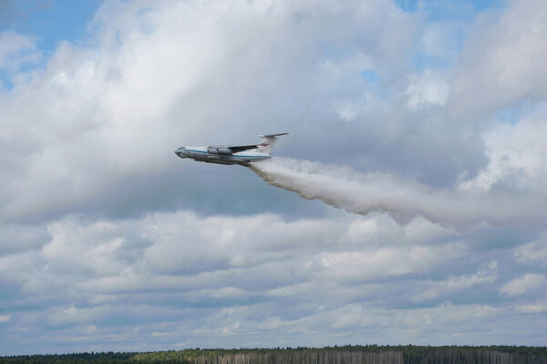 MILITARY GROUND ALABINO, MOSCOW OBLAST, RUSSIA - Aug 24, 2017: Russian fire plane IL-76 began dumping water over the training ground "Alabino" at the international military-technical forum ARMY-2017