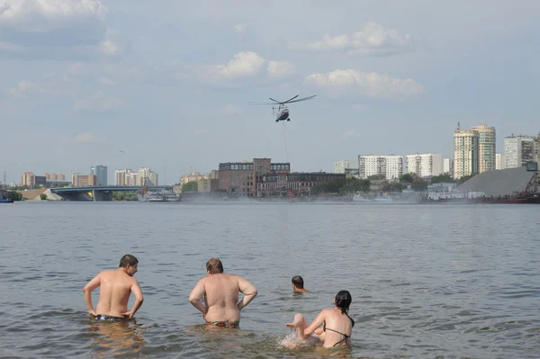 Fire helicopter Mi-26 takes water into the Khimki reservoir for fire fighting on Korovinskoe shosse, Tushino, Moscow — Stock Photo, Image