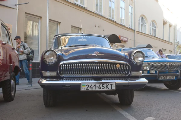 Carro preto retro soviético "Volga" GAZ-21 retro rali Gorkyclassic no estacionamento perto da loja de departamento de goma, Moscou, vista frontal — Fotografia de Stock