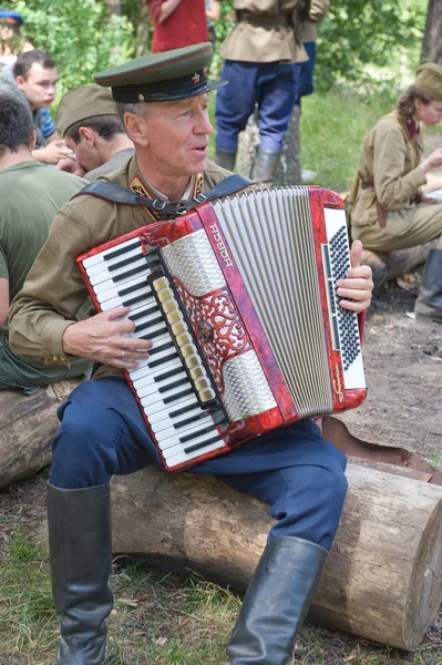 Accordionist at the bus stop to rest in the forest, 3rd international meeting "Motors of war" near the city Chernogolovka, Moscow region — Stock Photo, Image