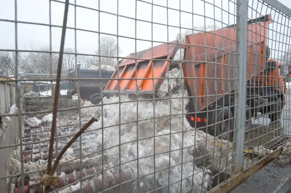 Την απαλλαγή του χιονιού από το πορτοκαλί σώμα του φορτηγού στο σημείο τήξης χιονιού, Μόσχα — Φωτογραφία Αρχείου