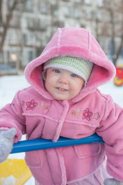 Tek ve bir yarım kız gülümseyerek, atlıkarınca üstünde duran bir pembe sheepskin eğlenceli. Kış.