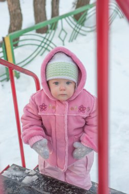 bir ve yarım bir kız duruyor yakınlarındaki bir tepe. Kış.