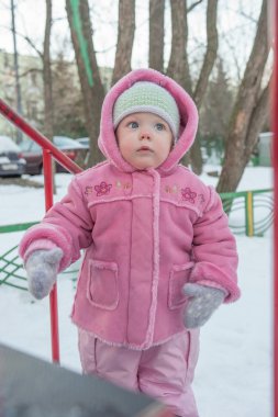 Tek ve yün eldiven bakar, yakınındaki tepenin ayakta bir yarım yıl-yaşlı kız. Kış.