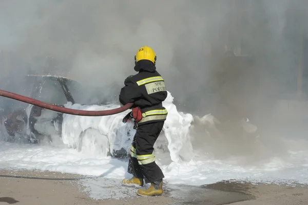 Um bombeiro extingue um carro sobre os ensinamentos do Ministério de situações de emergência, Moscou — Fotografia de Stock