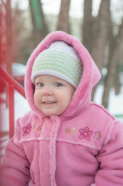 Year-old girl with round cheeks smiles happily, winter — Stock Photo, Image