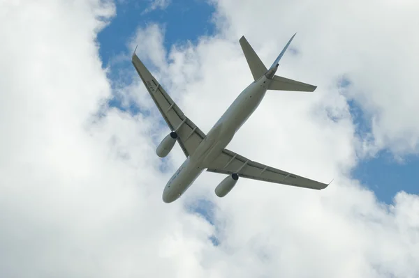 International aviation and space salon MAKS-2013, the flight of a new Russian passenger liner Tu-204 on a background of clouds — Stok fotoğraf