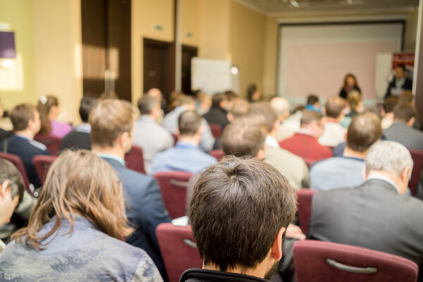 The audience listens to the acting in a conference hall.