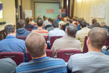 Arkadan görünüş oturan ve konferans salonunda dinleme yetişkin öğrenci