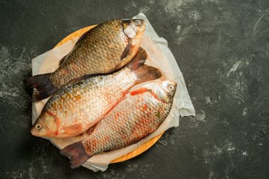 kopya alanı ile karanlık bir arka plan üzerinde üç ham sazan balıklar