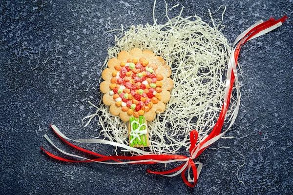 Nido de papel rallado con galletas caseras de árbol y lazo de cinta sobre fondo gris . —  Fotos de Stock