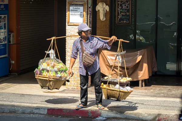 PHUKET, TAILANDIA - 13 DE ABRIL DE 2016: Vendedor de comida tailandés no identificado se para en la carretera con cestas . —  Fotos de Stock