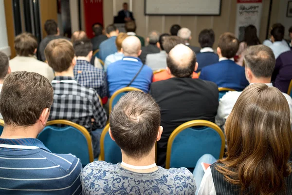 Zakelijke bijeenkomst - achteraanzicht od publiek luisteren de docent aan de conference hall — Stockfoto