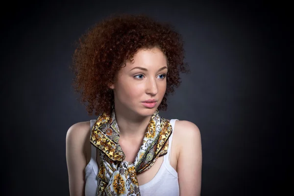 Retrato brillante de una hermosa joven pelirroja en un cravat sobre un fondo oscuro — Foto de Stock