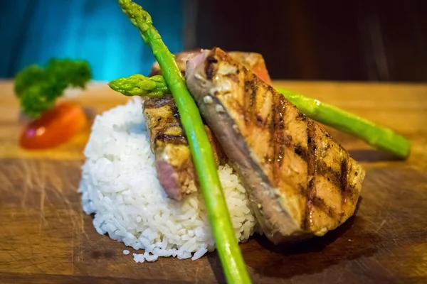Tuna steaks with white rice served on a wooden cutting board — Stock Photo, Image