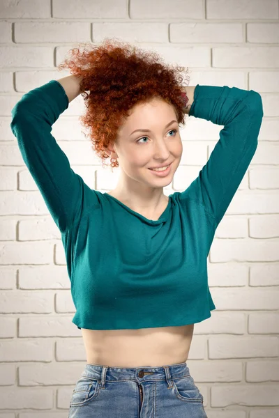 Porträt eines attraktiven jungen rothaarigen Mädchens, das seine Haare arrangiert — Stockfoto