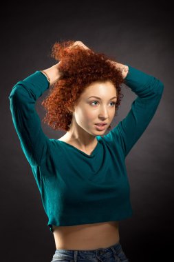 Genç güzel kadın saç koyu arka plan karşı düzeltir