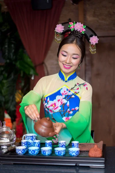 Красивая китайская женщина в традиционной одежде наливая чай во время чайной церемонии — стоковое фото