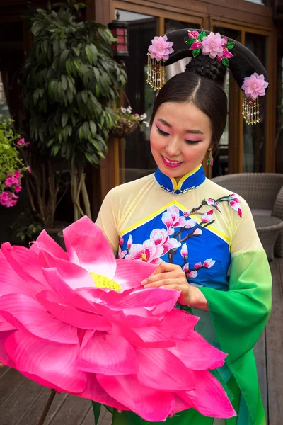 Mooi Aziatisch meisje in traditionele chinese groene en blauwe jurk met paraplu als een bloem — Stockfoto