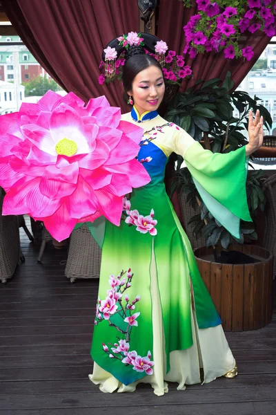 Vackra asiatiska flicka i traditionell kinesisk klänning och blommor parasoll — Stockfoto