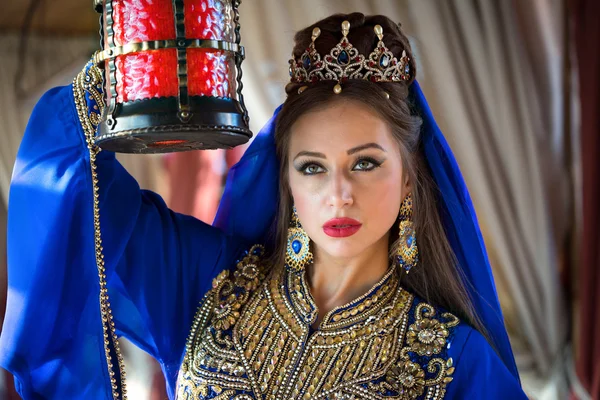 Mulher árabe em vestido tradicional segurando lâmpada vermelha iluminando o caminho — Fotografia de Stock