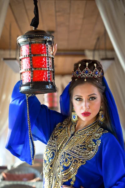 Mulher árabe em vestido tradicional segurando lâmpada vermelha iluminando o caminho — Fotografia de Stock