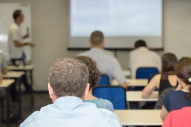 arka ve öğretmen masanın yanında iş toplantısında oturan insanlar