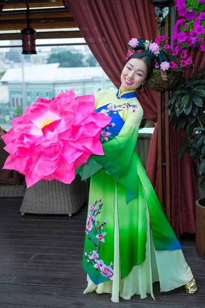 Красивая китайская женщина в зеленом традиционном платье и цветочный зонтик — стоковое фото