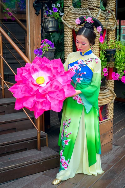 Vacker kinesisk flicka i nationella klänning med ett paraply i form av en blomma — Stockfoto