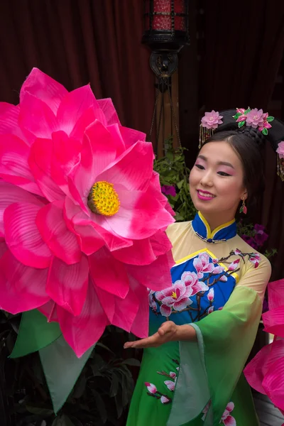 Mooie Chinese meisje in nationale klederdracht met een paraplu in de vorm van een bloem — Stockfoto