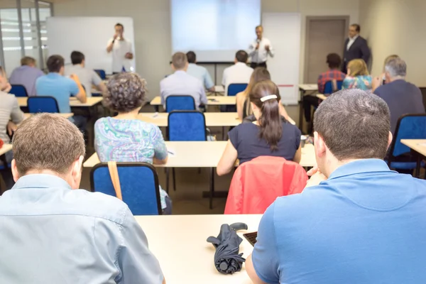 The audience listens to the acting in a conference hall. Focus is under the man on the front ground — Stock Photo, Image