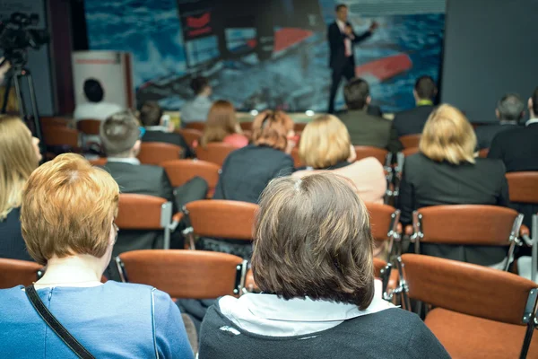 Rückansicht von Geschäftsleuten, die aufmerksam zuhören, während sie auf einer Konferenz sitzen — Stockfoto